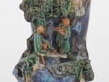 un vase bleu orné d'une figurine représentant un homme et une femme dans une forêt