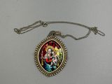 un gros plan sur un collier orné de la photo d'une femme tenant un enfant dans ses bras