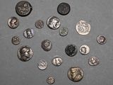 Plusieurs types de pièces de monnaie sont disposés en cercle sur une surface grise.