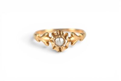 a close up of a gold ring with a pearl in it