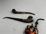 une pipe et un porte-pipe posés sur une surface blanche