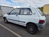 a picture of a small white car parked in a parking lot