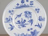 a blue and white plate with birds and flowers on it