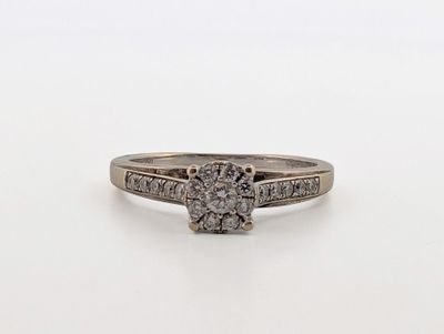 a white gold ring with a diamond center stone and two rows of diamonds
