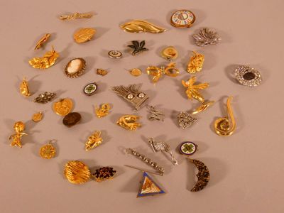 de nombreuses broches en or et en argent posées sur une table