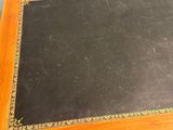 a black book with gold trim sitting on a wooden table