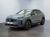 Une voiture grise est garée dans une pièce aux murs blancs.