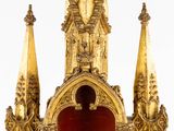 a gold clock with a red cover on it