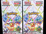 two packs of pokemon trading cards are shown on a black background