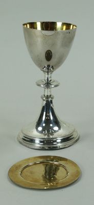 une coupe en argent et une assiette en or posées sur une table