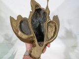 une personne tenant un objet en bronze dans la main