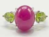 une image représentant une bague rose ornée de péridots et d'une pierre verte