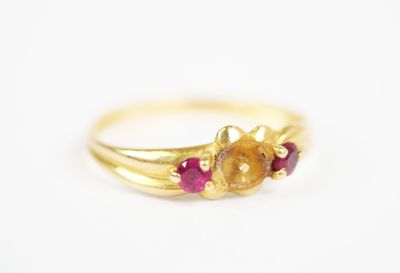a close up of a gold ring with three red stones