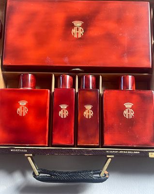 un coffret rouge contenant quatre bouteilles, posé sur une table