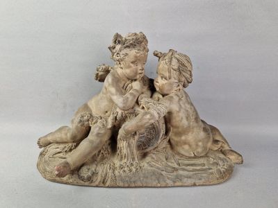 une statue représentant un garçon et une fille assis sur un rocher