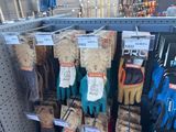 several pairs of gardening gloves hanging on a rack in a store