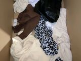 une boîte remplie de vêtements et une paire de chaussures