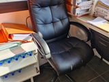 a black office chair next to a desk with a computer on it