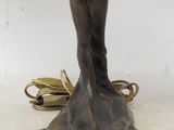 bronze statue of a woman holding a bird on a table