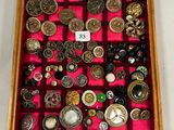 une boîte en bois remplie d'une multitude de boutons et de broches