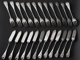 a lot of forks and knives on a black table