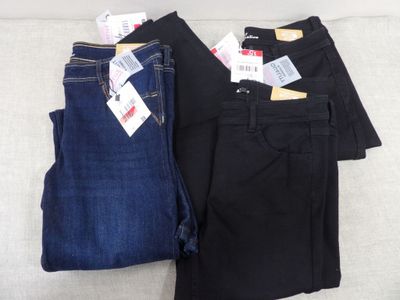 Deux paires de jeans pour homme sont posées sur un canapé.