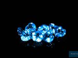 three blue diamonds are sitting on a black surface