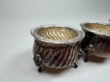 two silver pots sitting next to each other on a table