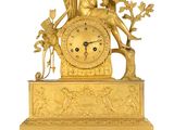 a gold clock with an angel sitting on top of it