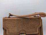 an image of a brown crocodile skin purse with a gold buckle