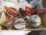 une boîte remplie de vieux ustensiles de cuisine posée sur une table