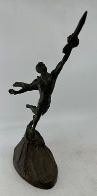 statue d'un homme tenant une batte de baseball, posée sur un socle en bois