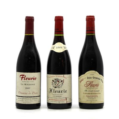 three bottles of wine are lined up on a white surface