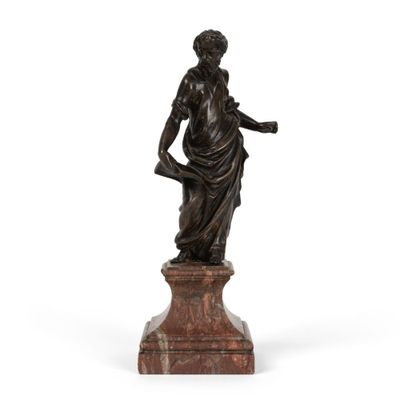 une statue en bronze représentant une femme tenant un enfant dans ses bras, posée sur un socle