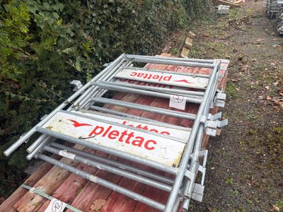 une pile de panneaux « Pletac » posée sur le bord de la route