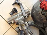 a vacuum that is sitting on the floor next to a hose