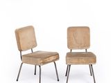 pair of mid - century chairs with upholstered backrests and metal legs
