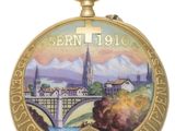 an image of a gold pocket watch with a picture of a town