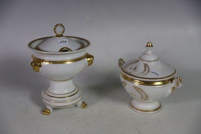deux vases blancs et dorés posés sur une table blanche