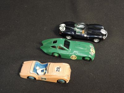 three toy cars that are sitting on a black surface