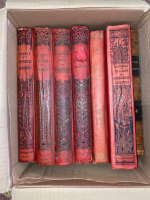 many books in a box that are sitting on the floor