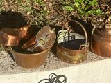 a lot of old copper pots and pans on the ground