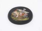 une image représentant une assiette noire ornée d'un oiseau et de fleurs