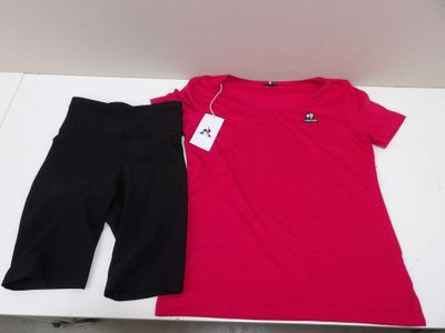 pink shirt and black pants on a table with a price tag