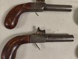 three old guns are displayed on a table with a white background