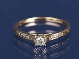 un gros plan d'une bague en diamant posée sur une surface bleue