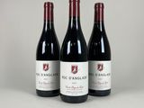 three bottles of red wine sitting on top of a table