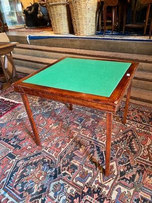 a table with a green top sitting on a rug