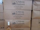 des cartons empilés les uns sur les autres, avec une bouteille de vin posée devant