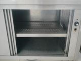 a stainless steel cabinet with a door open on a tile floor
